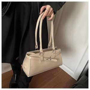 Detail view of beige PU leather shoulder bag with decorative straps and metallic buckles