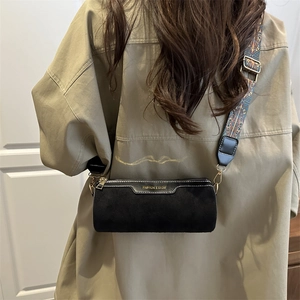 Chic black barrel bag with colorful ethnic pattern strap and golden hardware