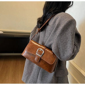 Side view of a vintage caramel brown shoulder bag with silver buckle and knot detail