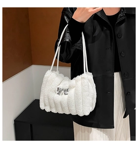 Détail du sac à main en peluche blanche avec nœud métallique et bandoulière