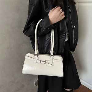 Chic off-white rectangular leather handbag with metal buckle worn with a black jacket