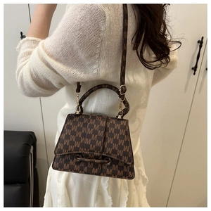 Brown crossbody bag with all-over M-letter pattern shown in a daily lifestyle setting