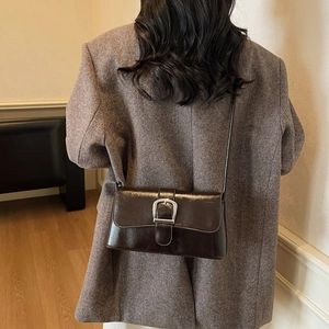 Retro dark brown crossbody bag with silver square buckle worn with a woolen blazer