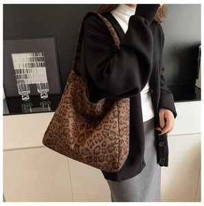 Detailed close-up of large leopard print hobo bag with wide shoulder strap in canvas material