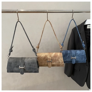 Tres bolsos de ante gris, caqui y azul con hebilla metálica plateada y detalle nudo