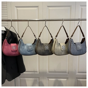 Row of five hobo bags in various colors with metallic M logo and leather straps