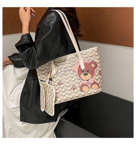 Detail view of large tote bag with cartoon bear print and matching small pouch