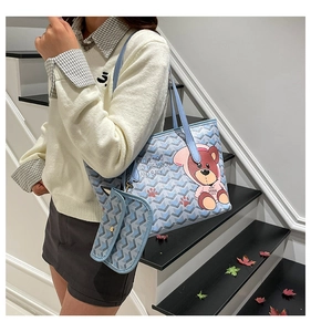 Detail of light blue tote bag set featuring a cute cartoon bear and chevron patterns