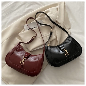 Détail de sacs hobo demi-lune avec fermoirs métalliques dorés et cuir lisse brillant