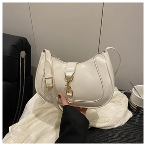 Détail d'un sac hobo crème avec fermoir mousqueton doré et texture brillante