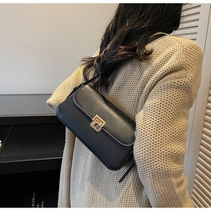 Détail du sac bandoulière en cuir noir avec son fermoir à pression carré doré