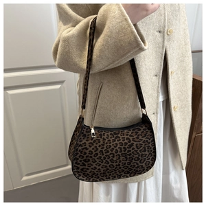 Détail du sac bandoulière léopard avec fermeture éclair dorée sur manteau en laine