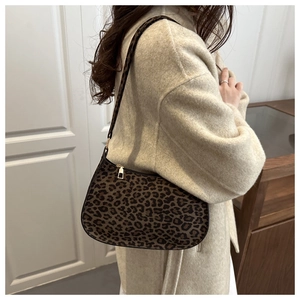 Détail du sac hobo léopard porté avec un manteau en tweed beige pour l'hiver