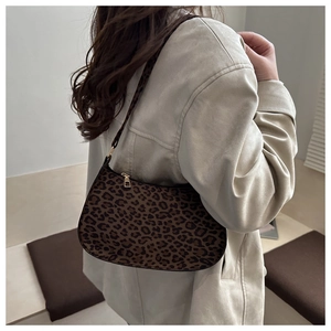 Detailed shoulder view of the leopard print hobo bag worn by a model in soft lighting