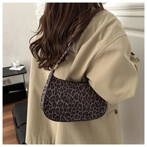 Close-up of stylish leopard print underarm bag worn with a classic beige trench coat