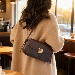 Sac à bandoulière en cuir marron foncé minimaliste avec boucle dorée, style d'hiver