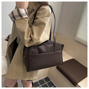 Detail of dark brown leather Boston shoulder bag showing front pocket and zip closure