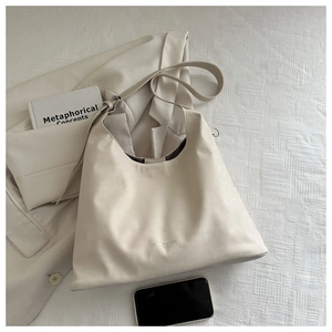 Flat lay of beige leather tote bag with stylish shoulder strap and fashion accessories