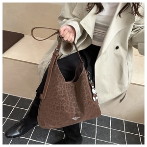 Brown leopard print hobo bag worn with a beige trench coat for a stylish winter look