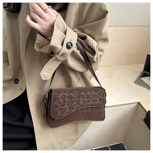 Close-up of leopard print shoulder bag with a matte texture on a beige coat model