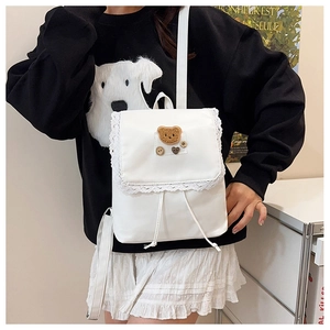 Dettaglio dello zaino bianco stile JK in nylon con bordo in pizzo e stemma orsetto