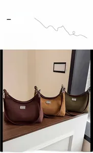 Détail de sacs à bandoulière demi-lune en marron, kaki et vert avec boucles métal