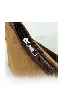 Détail de la fermeture éclair argentée sur sac à main en daim marron et cuir croco