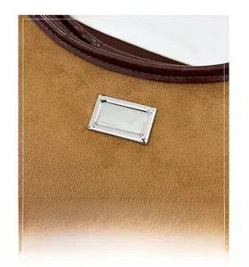 Détail macro de la texture en daim fauve avec bordure en cuir et plaque en métal argenté