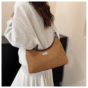 Détail du sac croissant en daim caramel avec bandoulière en cuir marron foncé