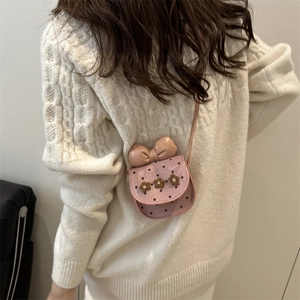 Mini sac à bandoulière rose à pois avec nœud et fleurs sur un pull blanc
