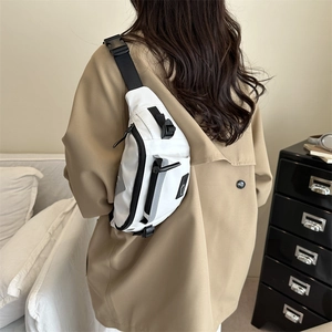 Modern white crossbody fanny pack with adjustable black strap and reflective detail