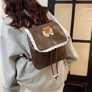 Zaino marrone in PU con bordo in pizzo e toppa a forma di orsetto, indossato da modella