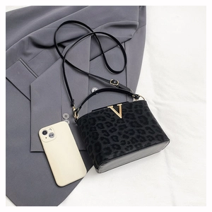 Detail of leopard print handbag with golden V-logo decoration and long shoulder strap