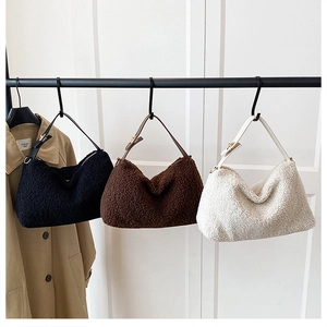 Detailed view of plush lambskin texture and leather handle on three winter handbags