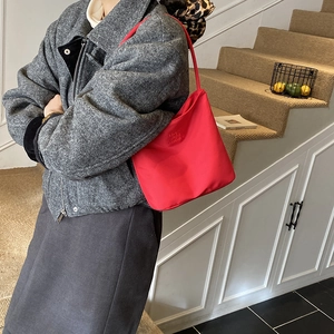 Sac seau rouge brodé chic pour femme, sac à bandoulière tendance en nylon sur modèle