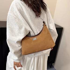 Sac hobo vintage en daim marron avec garniture en cuir et plaque en métal