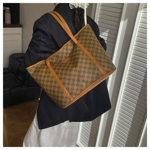 Model wearing a retro tan geometric print tote bag with long leather shoulder straps