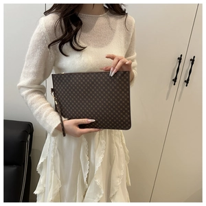 Détail d'une pochette enveloppe vintage marron foncé avec imprimé logo classique