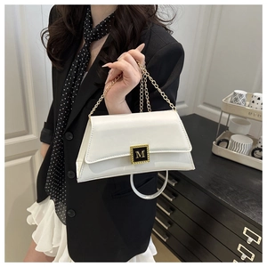 Chic white leather crossbody bag with gold M-buckle and chain strap shown on a model