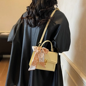 Pale yellow leather crossbody square bag with scarf handle and gold buckle detail