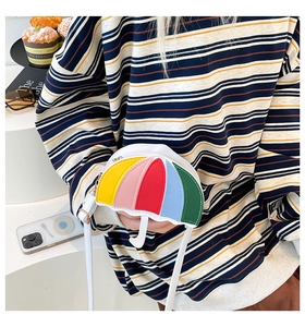 Detail of creative umbrella-shaped crossbody bag with colorful panels and white handle