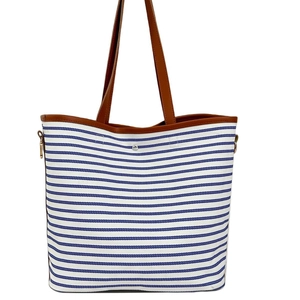 Blau-weiß gestreifte Canvas-Tragetasche mit braunen Ledergriffen und goldenem Verschluss