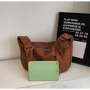 Détail du sac à bandoulière en velours côtelé marron avec boucle et grande capacité interne