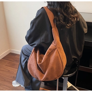 Vue détaillée du sac hobo en daim marron avec large bandoulière et forme décontractée