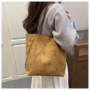 Detail of brown suede tote bag with cartoon line art and decorative side metal zipper
