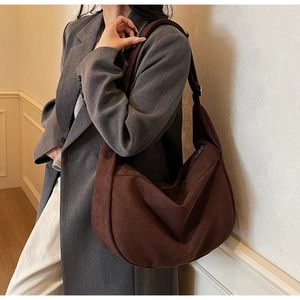 Detail of dark brown suede crescent shoulder bag showing matte texture and large capacity
