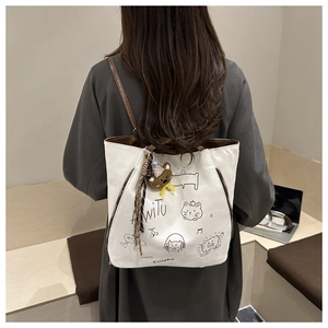 Detailed back view of a person carrying the white canvas tote bag with cute animal patterns