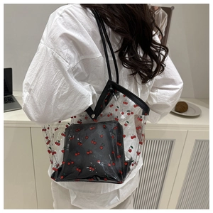 Lifestyle view of clear PVC tote with cherry print and inner black bag on model