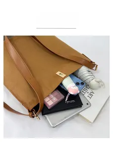 Detail view of large capacity brown suede tote bag showing internal storage items
