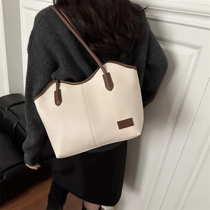 Large beige and brown faux leather tote bag with pebble grain texture shown by model